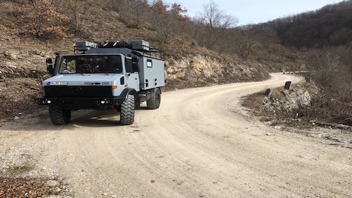 Unimog auf Schotterstrasse zur Burg