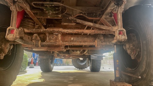 Unimog von unten voller rotem Sand